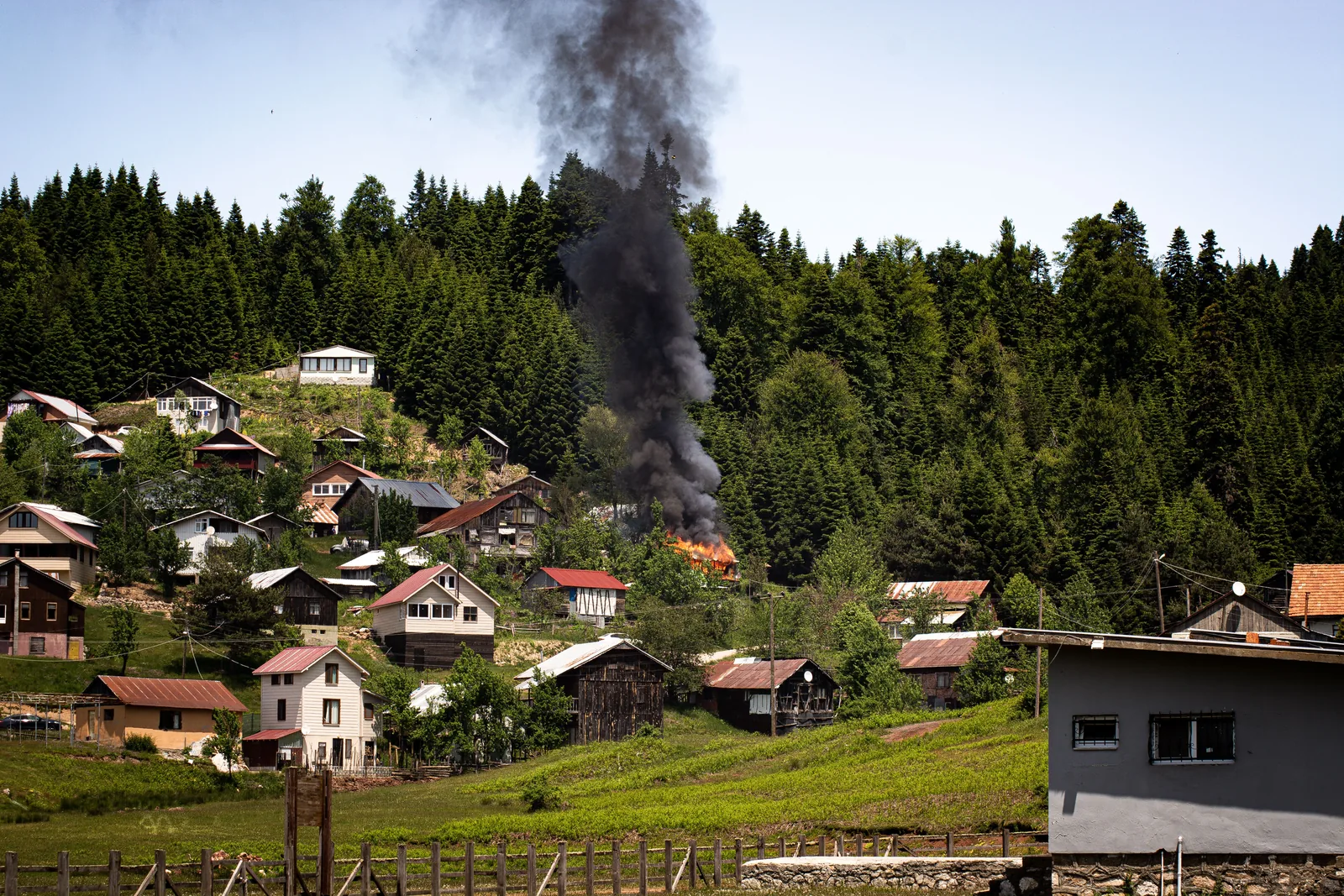 Viviendas próximas a una zona afectada por un incendio forestal y servicios de emergencia