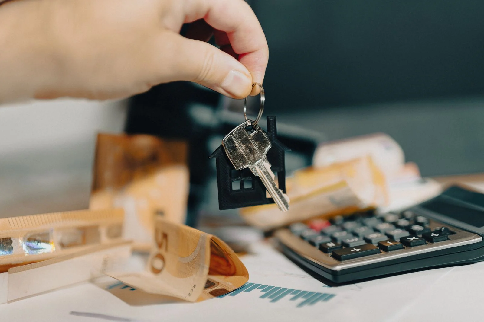 Llaves de una vivienda en alquiler sobre billetes de euro y una calculadora, reducción por alquiler de vivienda en el IRPF
