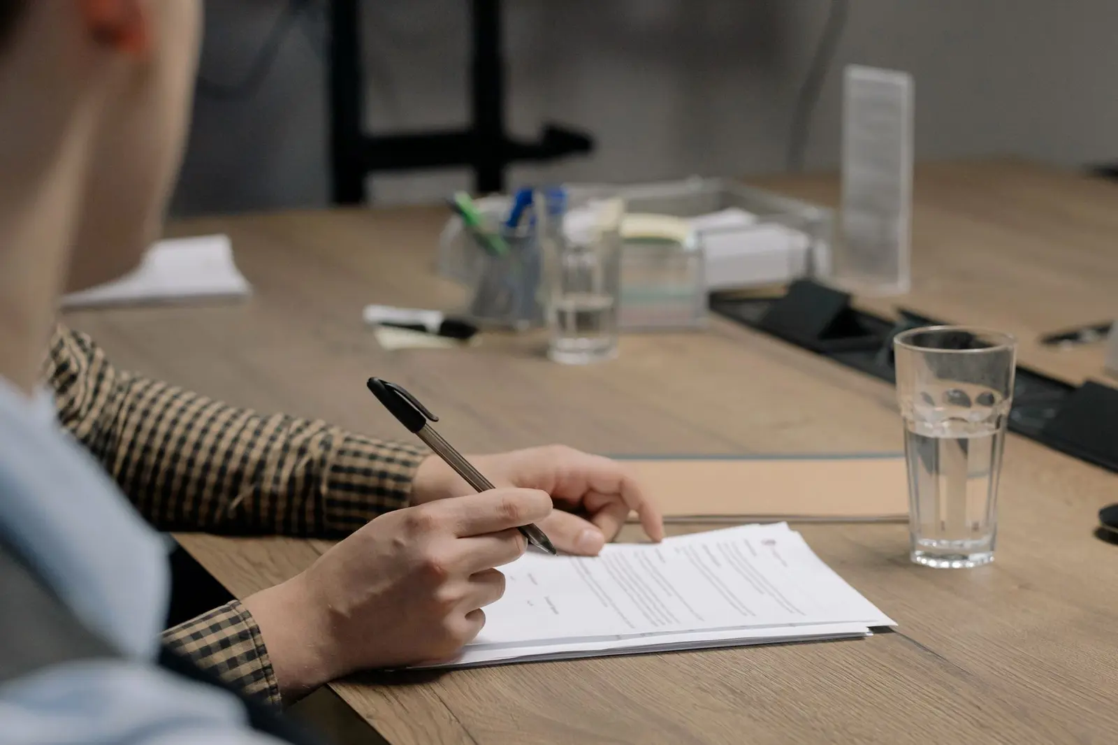 Persona firmando un documento sobre una mesa