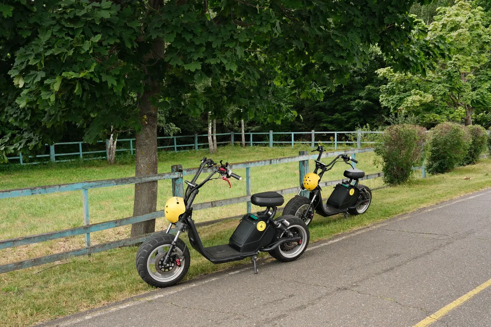 Patinetes eléctricos con casco aparcados junto a la carretera